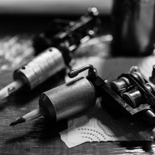 close-up-view-of-tattoo-machines-on-wooden-tableto-ST2B7XT.jpg